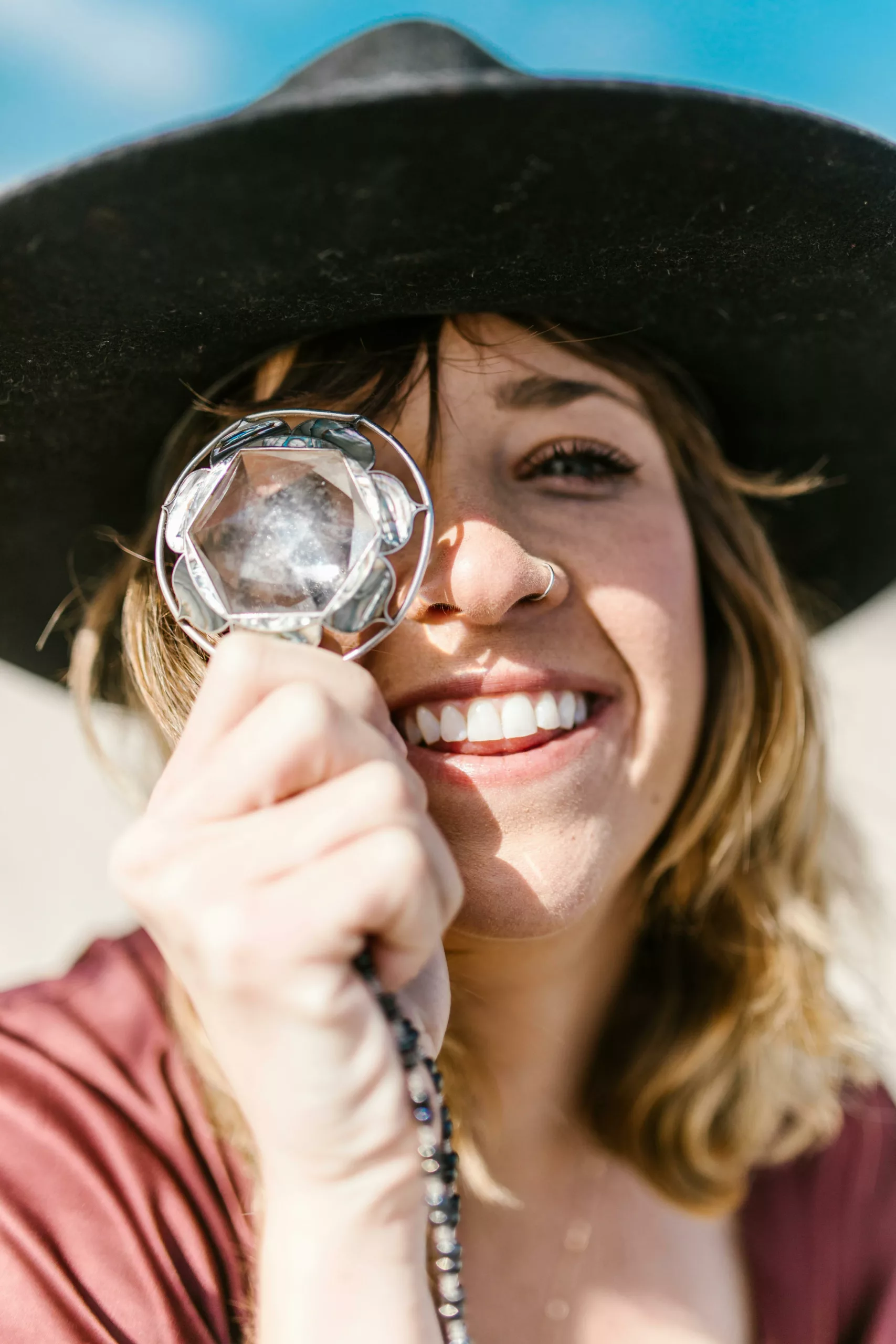 Smiling woman holding a crystal, symbolizing clarity and positivity